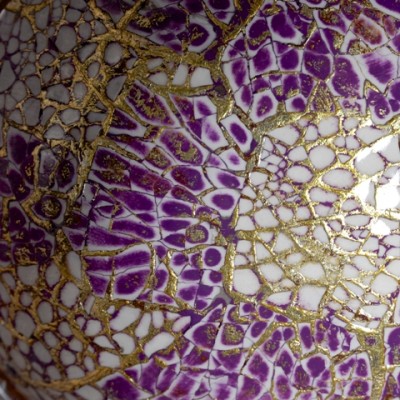 Close up view of purple coconut bowl with eggshell and gold.